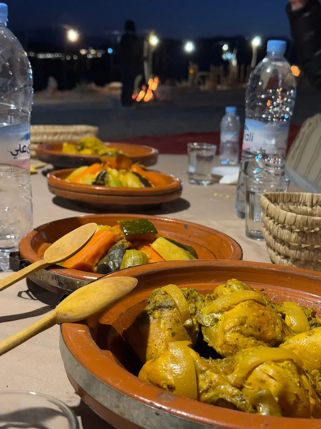 Tagines served at dinner in a camp after dark