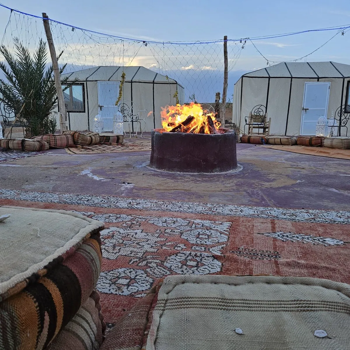 A desert camp lit at nightfall