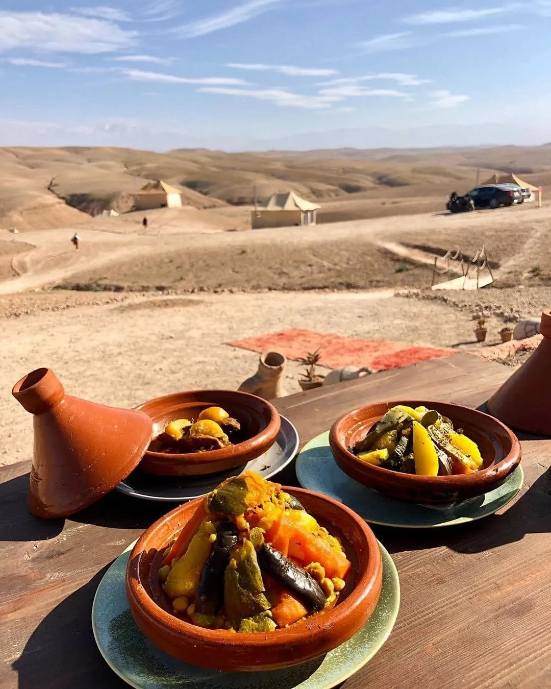 Tagines served on a table facing the stony hills of the Agafay desert