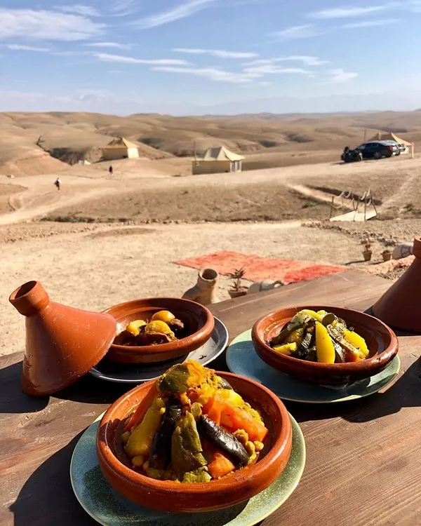 Tagines served on a table facing the stony hills of the Agafay desert