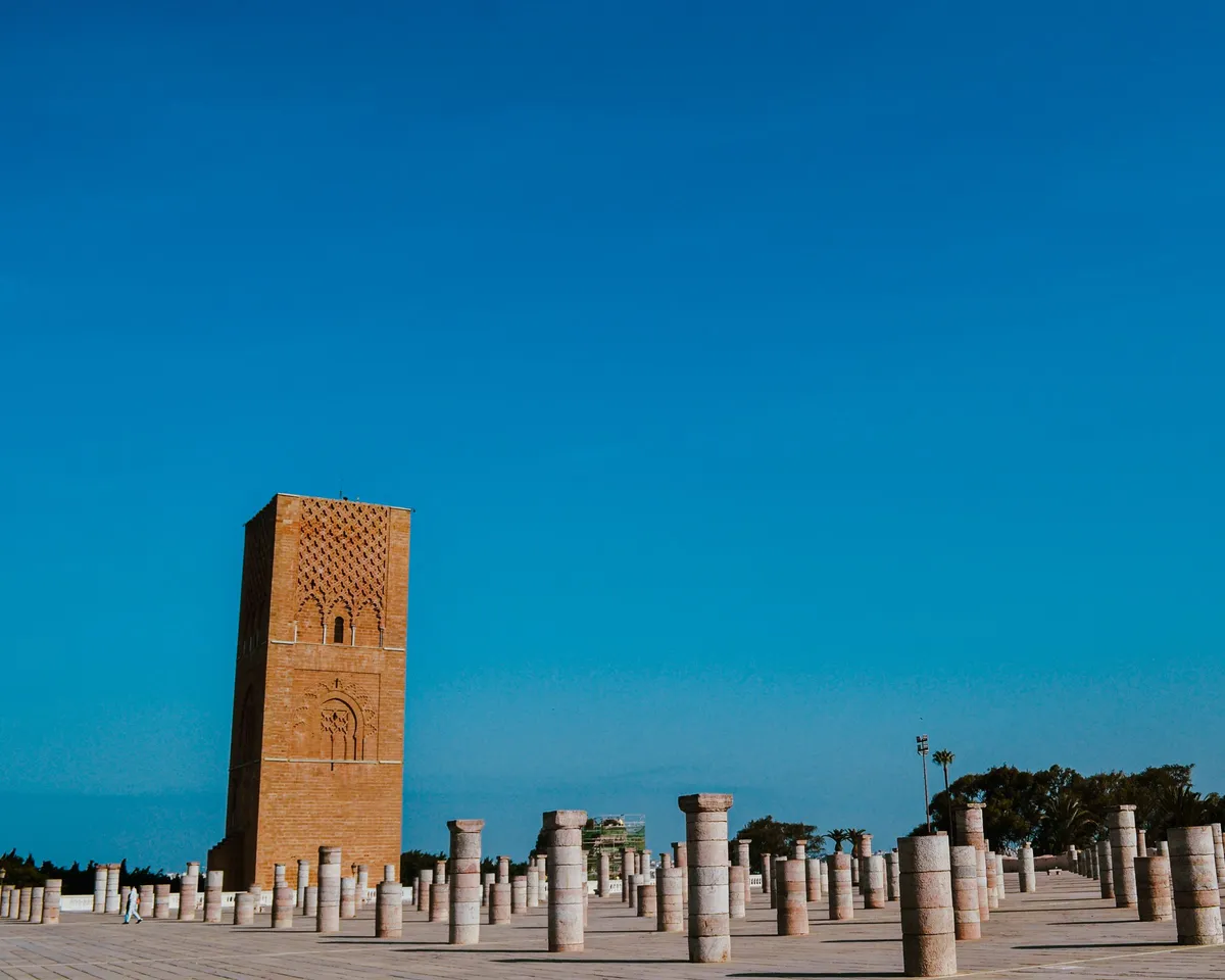 La tour Hassan en pierre ocre qui domine les rangées de colonnes de son esplanade, sous un ciel bleu profond
